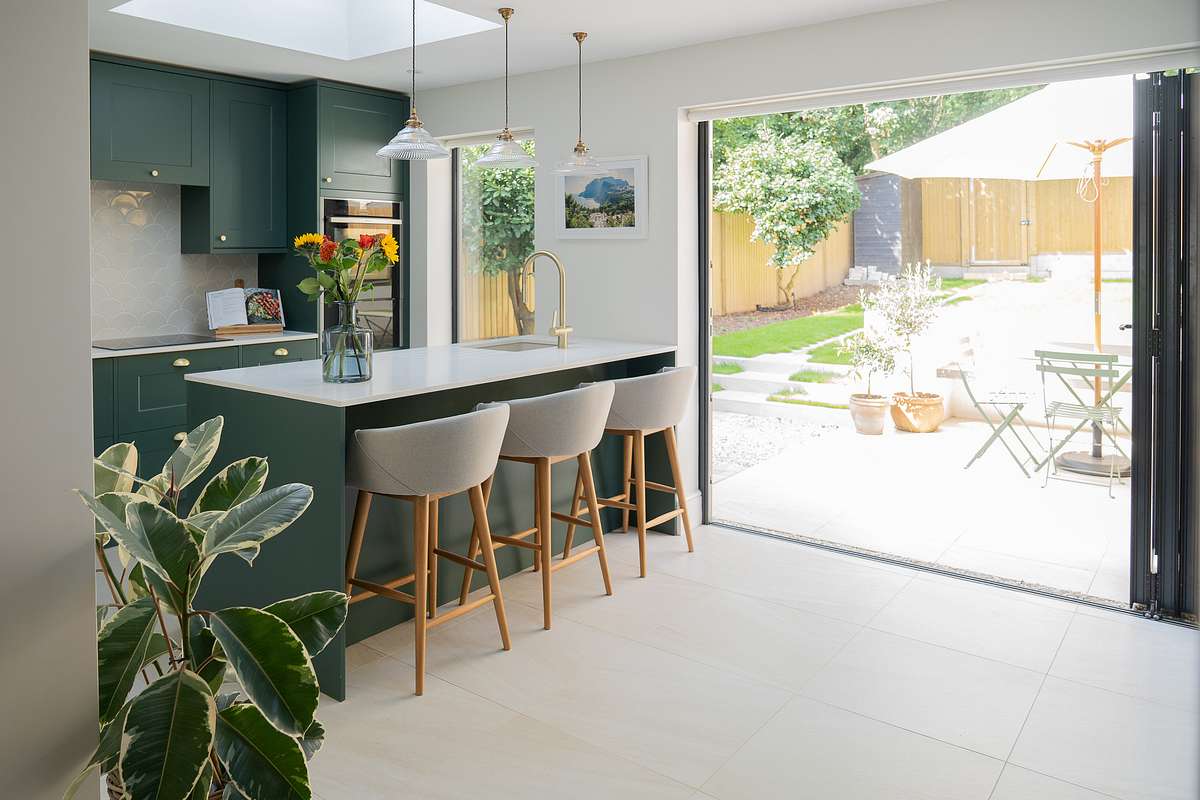 open plan kitchen and dining area with open doors to garden