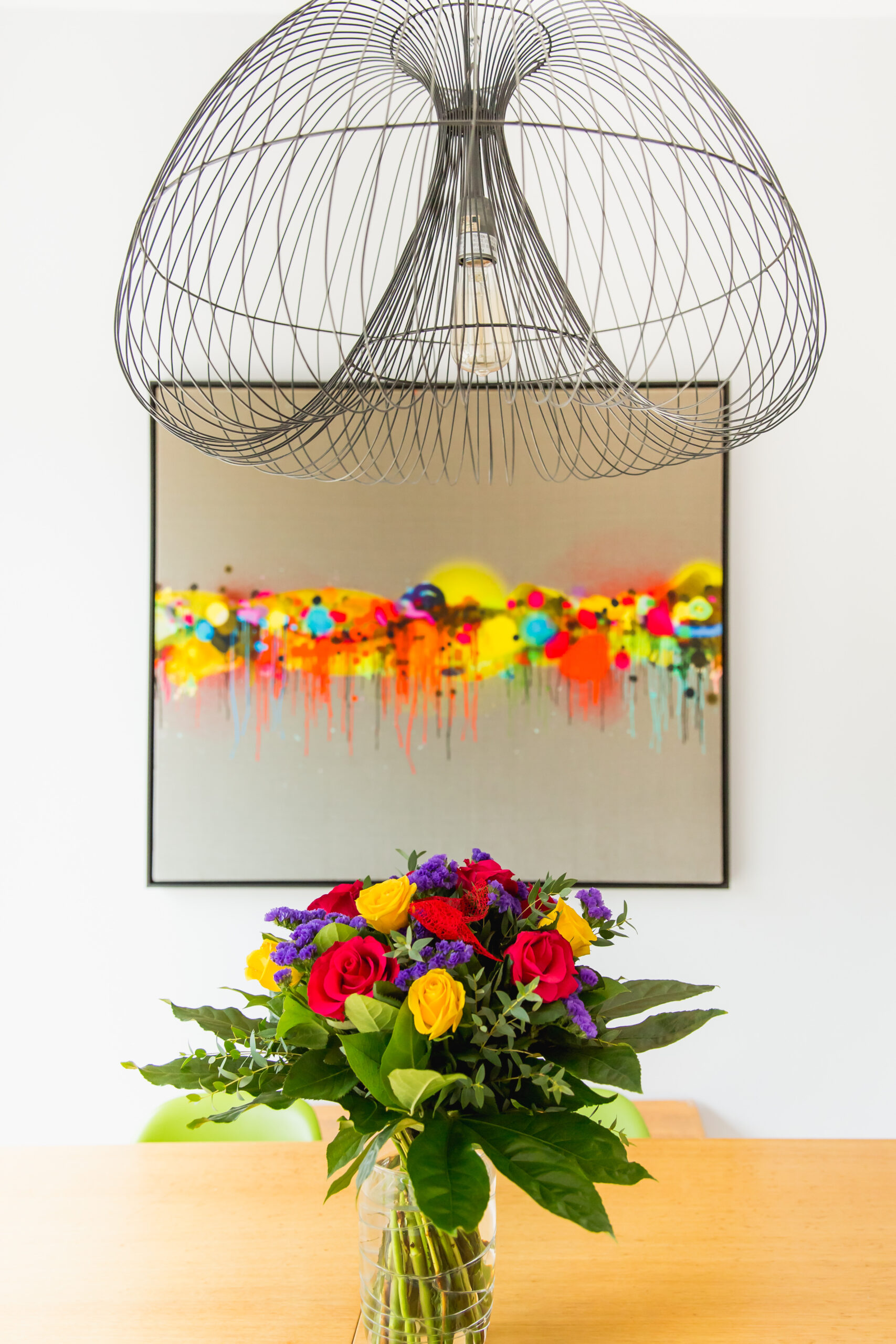 light fitting, table with flowers and wall art